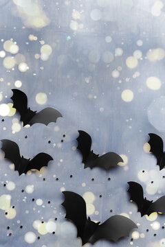 Silhouettes of flying black and dark grey bats on blue background with bokeh. Minimal and spooky holiday pattern for Halloween background, wallpaper, party invitations. Aesthetic top view, flat lay