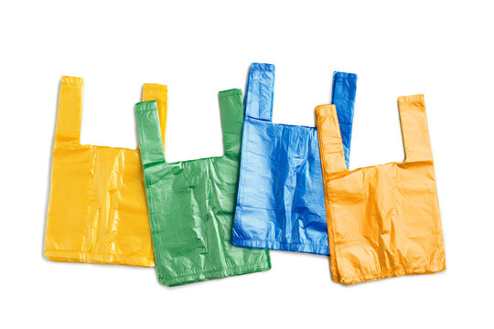 Colored single-use plastic shopping bags isolated on white background. Top view red, yellow, green, blue grocery bag, everyday consumer packaging and widespread use of disposable plastic products.
