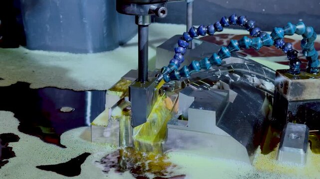 Close up of EDM machine eroding precision metal mold with dielectric coolant oil