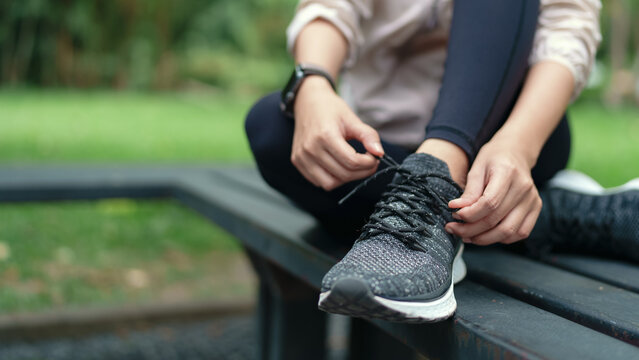 Female athlete tying shoelaces at the park