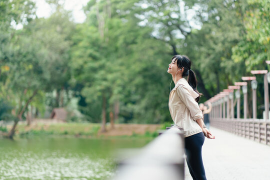 Attractive asian woman listening online music at outdoor.