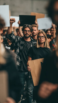 Protestors' Resolve: A determined crowd marches with signs held high, their faces a testament to unwavering conviction in a demonstration of collective voice.