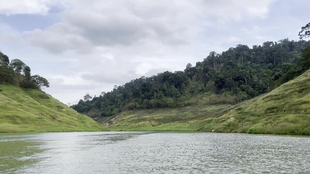 Scenic boat ride through a beautiful green valley and mountains at Khun Dan Prakan Chon Dam in Nakhon Nayok, Thailand