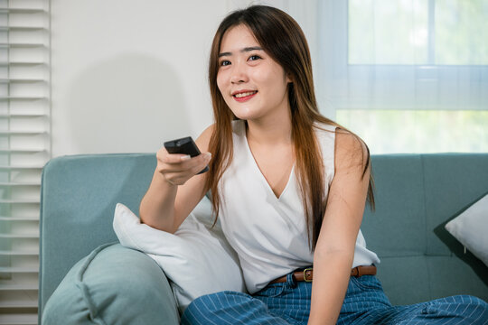 Happy female fun comedy video holding remote watching television