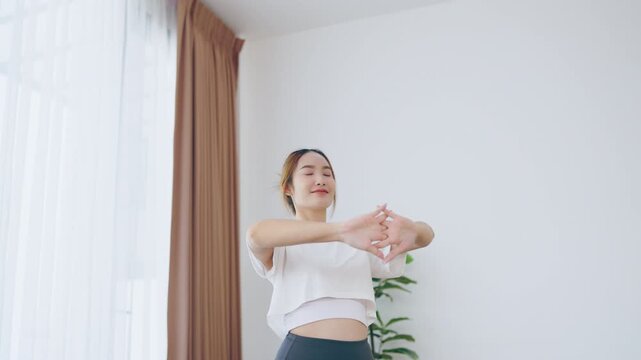 Young Asian beautiful woman doing stretch in the morning at home. Health care and body care concept