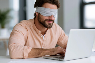 Fototapeta premium Man wears sleep mask while typing on laptop. He appears focused, relaxed, and calm. Soft lighting highlights his calm demeanor. Scene suggests work, study, or creative task
