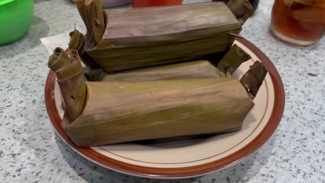 Traditional Indonesian Arem-Arem or Lemper Wrapped in Banana Leaf Served on a Plate