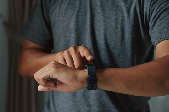 Warm close up of man hands adjusting smartwatch display, symbolizing seamless tech integration, smart productivity, and modern lifestyle balance