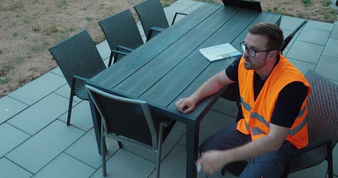 An exhausted construction worker takes a short break after demanding physical work on a residential project.
