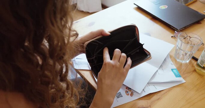 Close-up of an empty wallet in a woman's hands, highlighting financial hardship and lack of money.