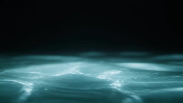 Aqua-toned water weaves through continuous gentle currents, light revealing moving surface texture and subtle depth against near-black with calming natural atmosphere and smooth motion.