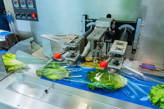 Food package wrapping machinery. Vegetable and fruit on flow packing machine. Food industry