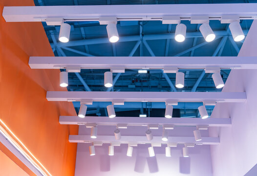 Directional LED lights on rails under the ceiling in a modern warehouse, shopping center building, office or other commercial real estate object.