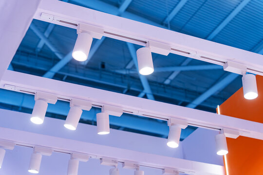 Directional LED lights on rails under the ceiling in a modern warehouse, shopping center building, office or other commercial real estate object.