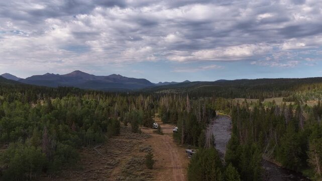 Aerial of wilderness camping and Bear River in Uinta Wasatch Cache National Forest with multiple parked RVs in Uinta Mountains in Utah in summer on sunny day