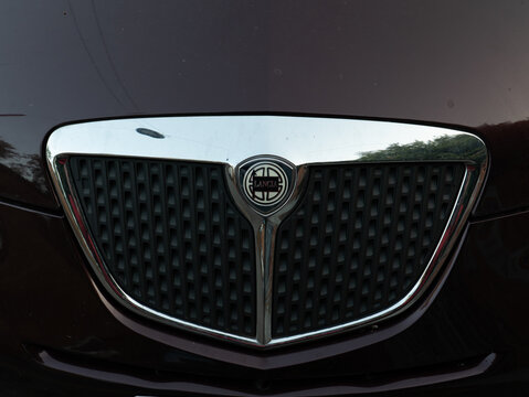 Lancia Ypsilon luxury car radiator grille with chrome trim and emblem showcasing automotive design detail