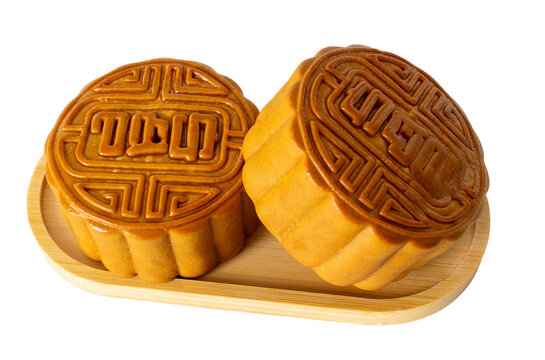 Two mooncakes on bamboo plate isolated on transparent background, tradition Chinese moon cake, sweet dessert for mid autumn celebration. Happy Chinese translation mid autumn festival.