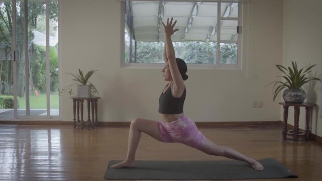 Flexible woman practicing yoga warrior pose sequence