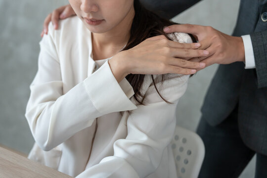 business man sexually harassed a female colleague by touch her shoulder. Sexual harassment in office. Women feel anxious and stressed from being harassed. molest, assault, inappropriate