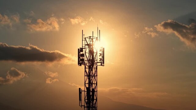 Silhouette of mobile network tower at sunset with dramatic clouds. Telecom, wireless technology, and connectivity concept footage.