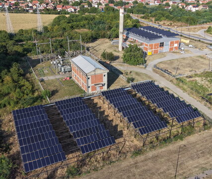 Aerial view of the solar panel farm in the south industrial zone featuring rows of photovoltaic panels, an electrical substation, and industrial buildings in Pancevo, Serbia.