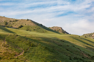 Obraz premium Rolling green hills under a soft blue sky