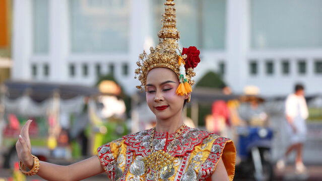 Traditional Thai Khon Dancer in Ornate Golden Costume on City Street