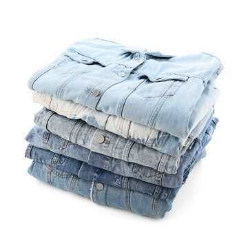 Stack of folded denim jackets in various shades of blue, casual fashion and clothing retail concept, isolated on a white background
