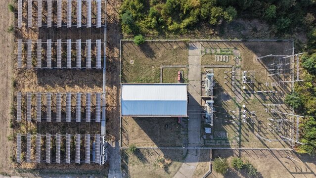 Aerial view of a solar power plant with rows of photovoltaic panels, a central utility building, and an electrical substation in the South Industrial Zone of Pancevo, Serbia.