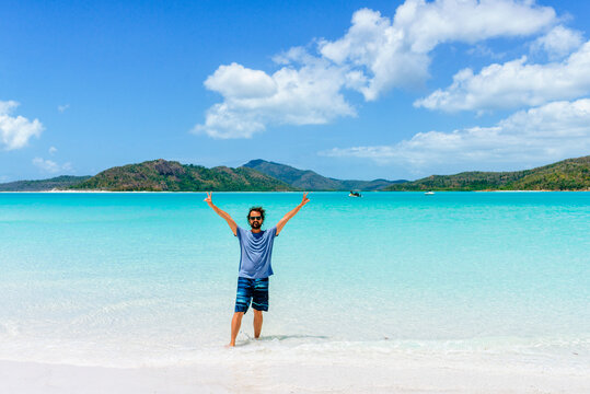 Happy man traveling Whitehaven Beach in Whitsunday Islands, Australia