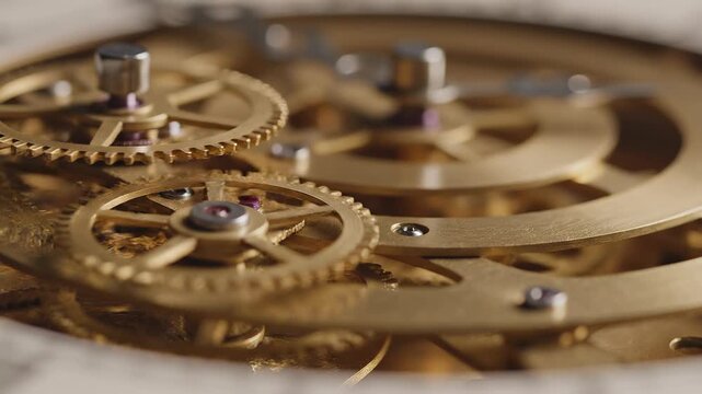 Intricate brass clockwork gears rotating smoothly in soft warm light with shallow depth of field