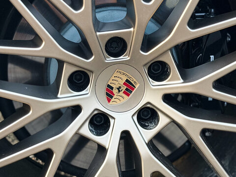 Close-up of a porsche alloy wheel with a detailed rim and center logo on a sports car