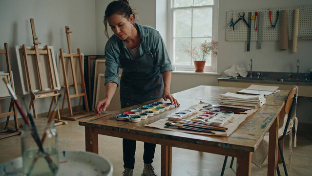 Art teacher organizes painting supplies before class