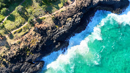 Aerial View of Waves Crashing Against Fingal Head Basalt Cliffs © blueringmedia