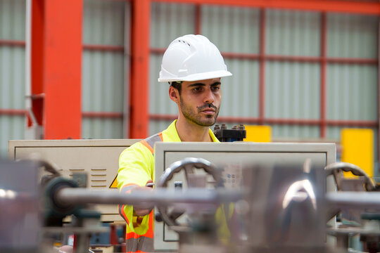 Technician Operating Equipment at Control Panel in Industrial Manufacturing Environment for Safety Protocol Training