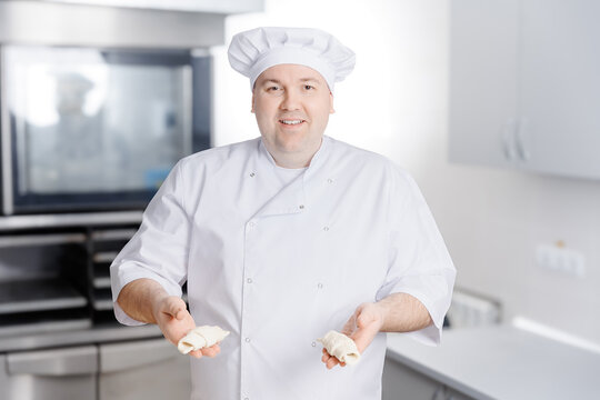 Pastry chef demonstrates freshly made puff pastries in kitchen restaurant
