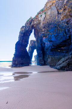 Natural rock arch formations on sandy beach coast As Catedrais Galicia Spain sea landscape