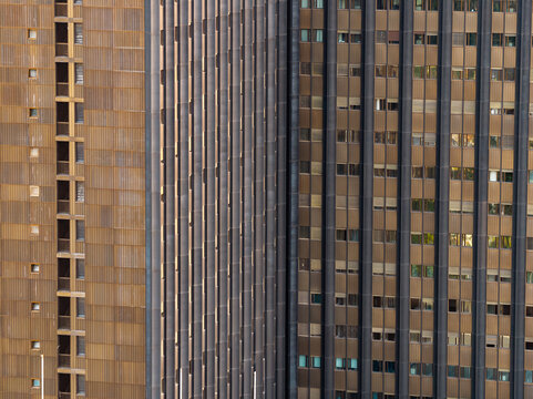 Aerial view of the modern architectural facade of the EUR district featuring repetitive bronze metallic panels and vertical window patterns in Rome, Lazio, Italy.