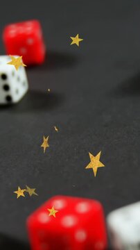 Animation of gold stars falling over white and red dice on grey background