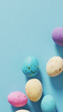 Animation of hand with easter decorations and easter eggs over blue background