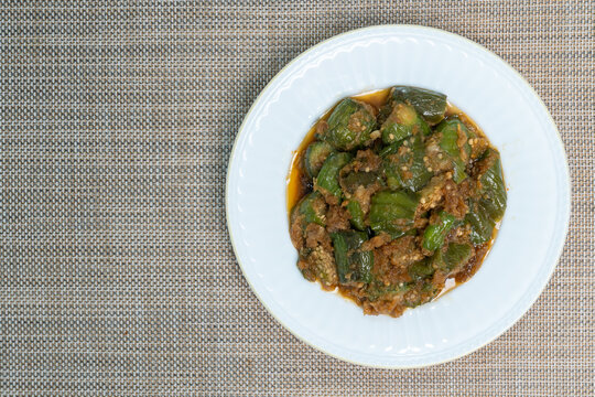Stir-fried ong eggplant (aubergine) with ground dried shrimp and fermented soybean paste in a white dish, Top view,