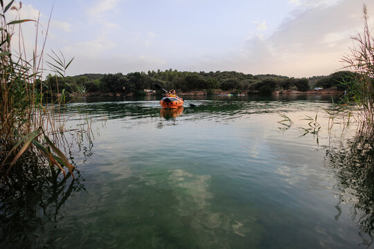 People paddling inflatable kayak exploring tranquil lake