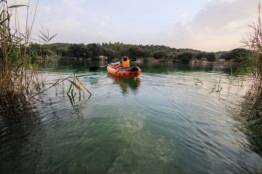 Person kayaking clear water exploring nature during summer