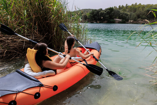Young women enjoying paddling in inflatable kayak