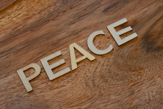 Peace spelled with wooden letters on a wood surface