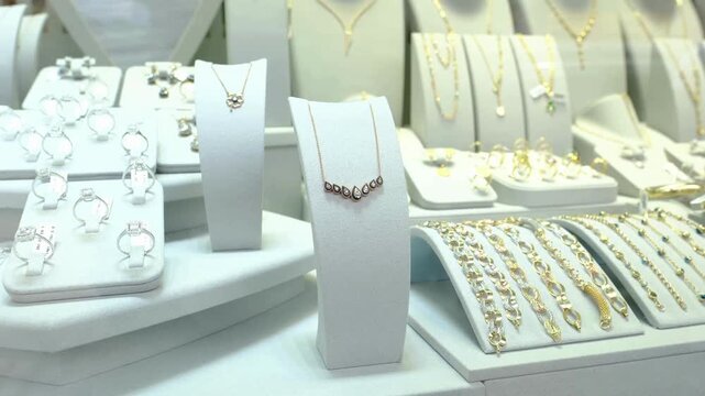 Elegant gold diamond necklace set displayed on velvet mannequin inside modern jewelry store showcase unit.