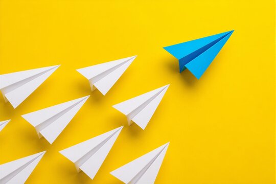 Paper planes flying toward right with blue leader on yellow background