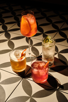 Colorful cocktails with citrus garnish on patterned table