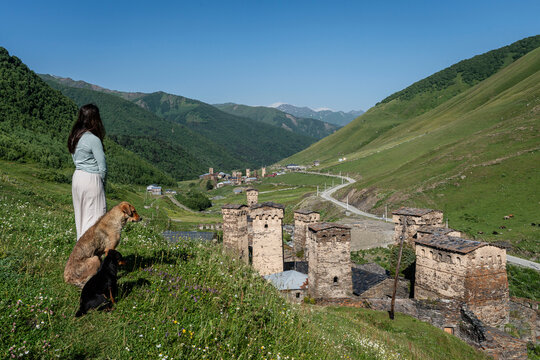 young woman watching Ushguli village, trans-Caucasian trail, Upper Svaneti, Caucasus mountain range, Georgia