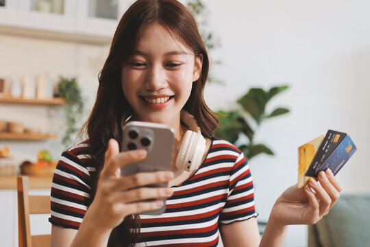 Happiness Entrepreneur beautiful business asian young woman wear casual use mobile phone for shopping online enjoy with social media and laptop at home.Small Business Startup.online banking